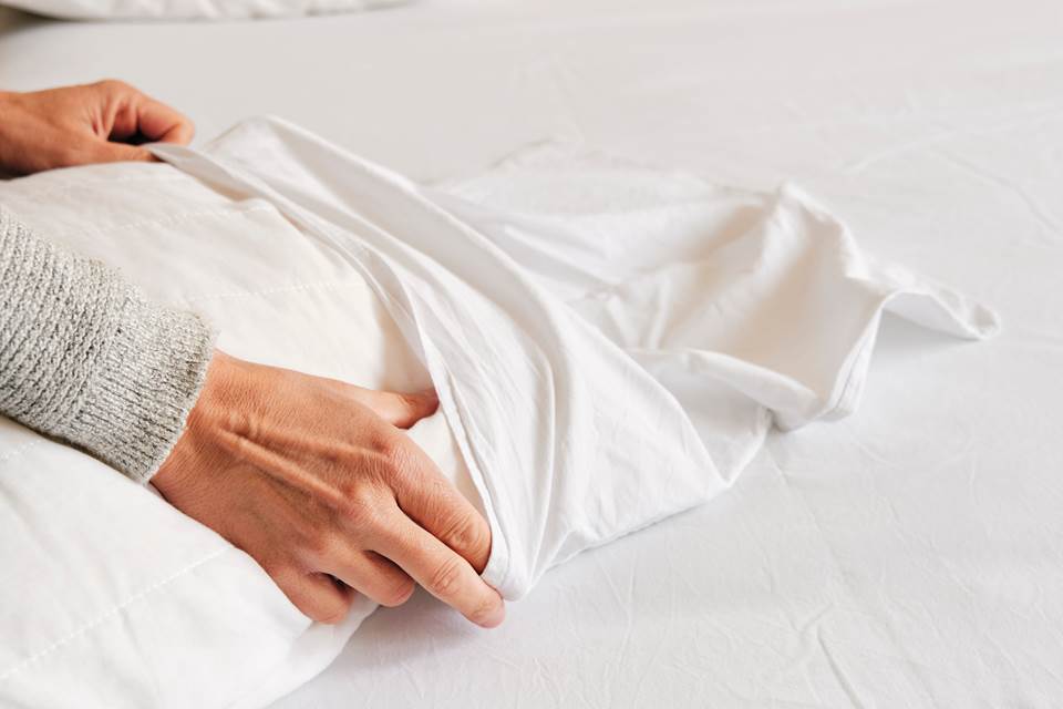 Person putting case on pillow
