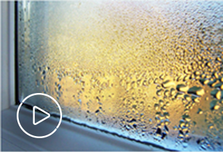 Image of window with condensation with white play button overlaying