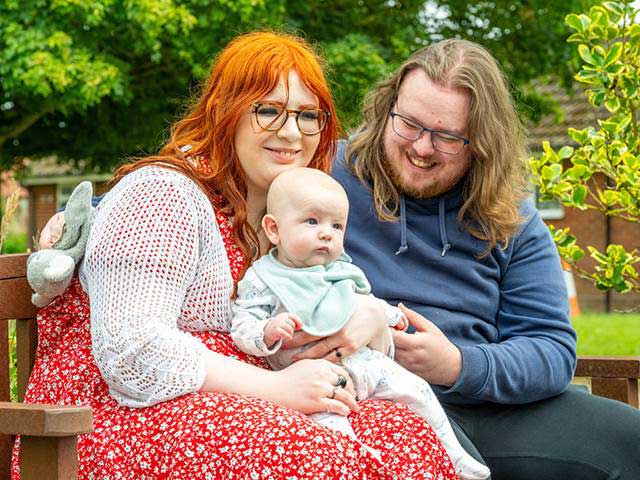 Couple on a park bench with child