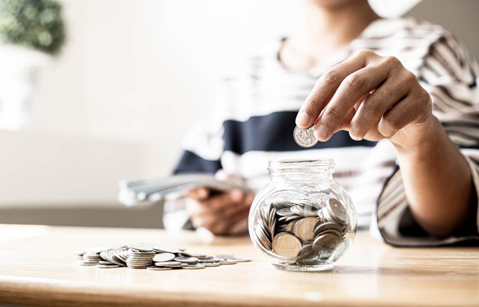 Person putting coins in a jar
