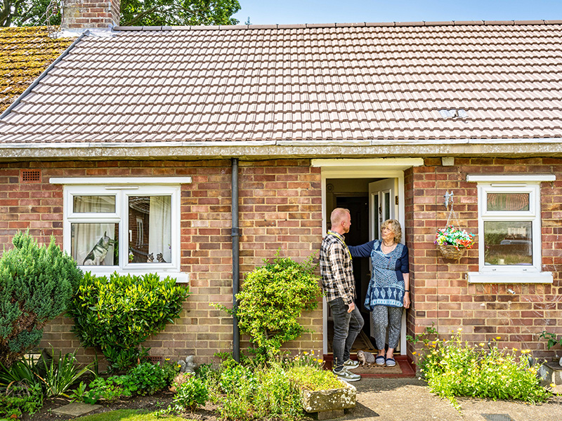 Man and woman outside a house