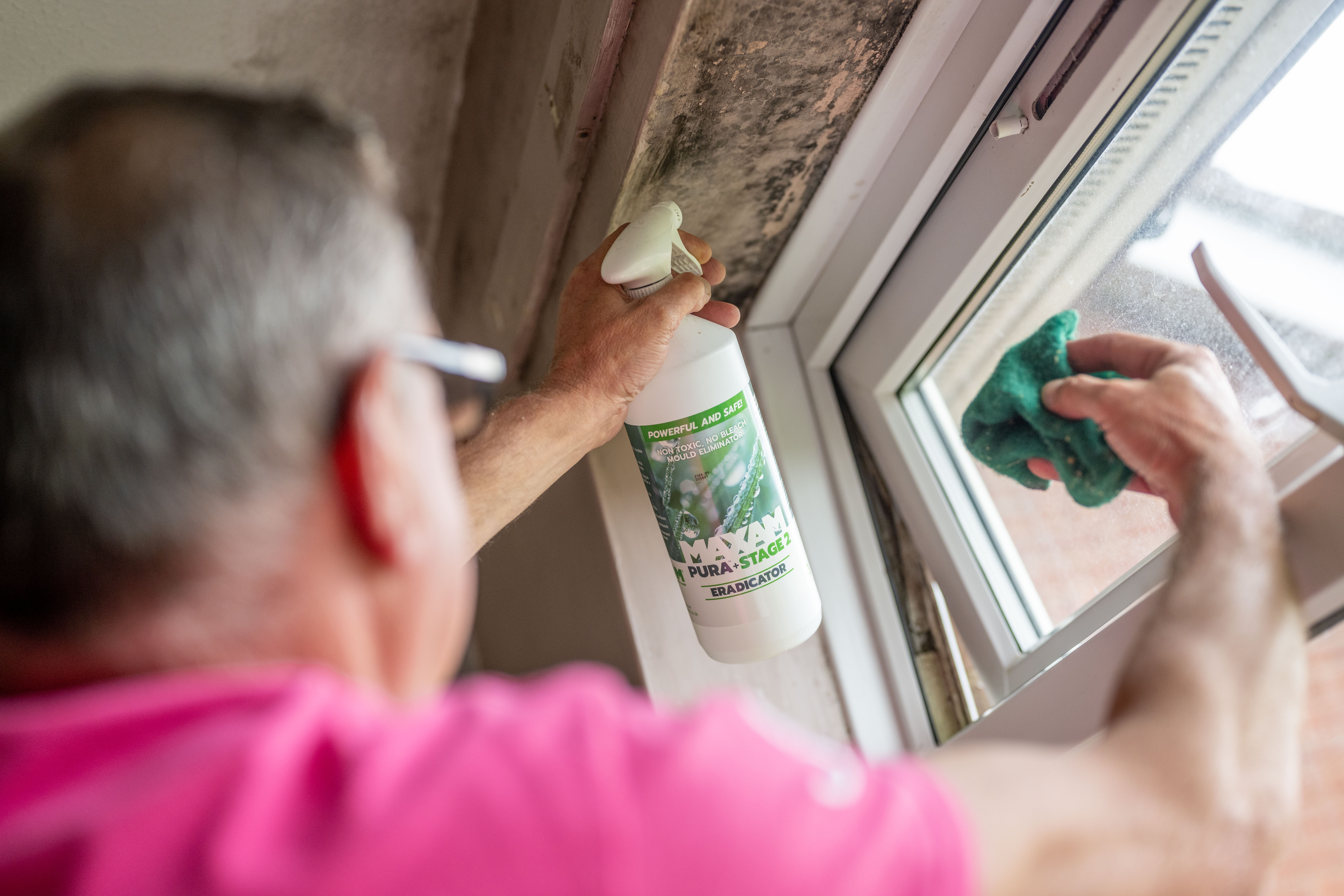 Man cleaning damp and mould